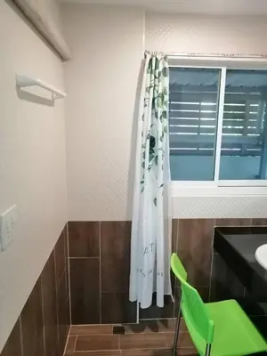 a bathroom with a green chair and a window at KS RESIDENCE Victory Monument in Bangkok