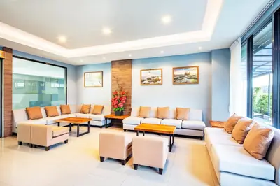 a living room with couches and tables and windows at Livotel Hotel Kaset Nawamin Bangkok in Bangkok