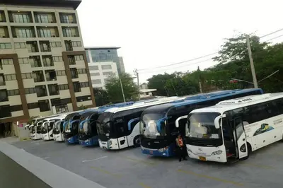 a row of buses parked in a parking lot at Livotel Hotel Kaset Nawamin Bangkok in Bangkok