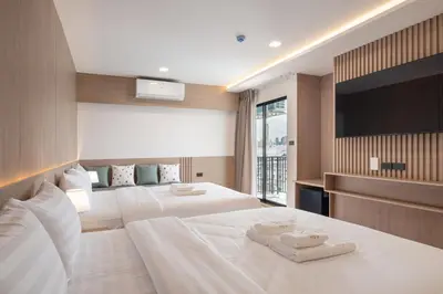 a hotel room with two beds and a flat screen tv at Solyn Hotel in Bangkok