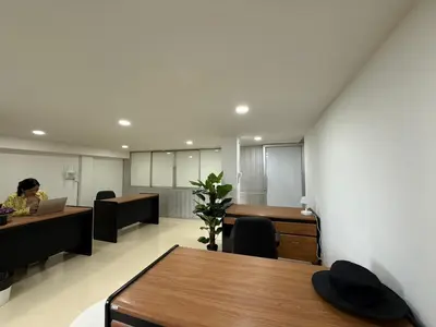 an office with a woman sitting at a desk with a laptop at Sukhumvit 48 separated room quiet and comfortable with fast internet and smart TV in Bangkok