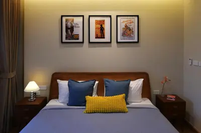 a bedroom with a bed with four pictures on the wall at Pillow & Paper in Bangkok