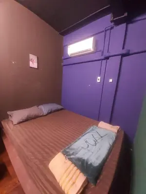 a bedroom with a large bed with a blue wall at RoXx Social Hostel in Bangkok