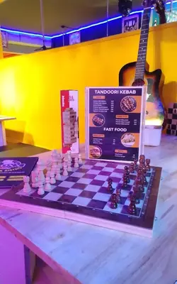 a chess board on a table with a guitar at RoXx Social Hostel in Bangkok