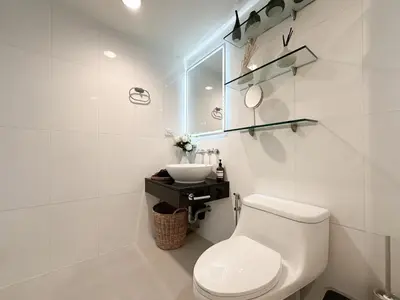 a white bathroom with a toilet and a sink at Prime Classic 1 BR BTS Chidlom 72SQM Langsuan in Bangkok