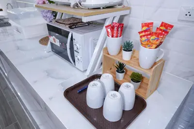 a kitchen with white cups and potted plants on a counter at CozyTwin Bed วิวระเบียง เจริญนคร in Bangkok
