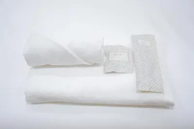 a stack of white towels and a book on a bed at CozyTwin Bed วิวระเบียง เจริญนคร in Bangkok