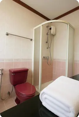 a bathroom with a red toilet and a shower at Omalaya Bangkok in Samphanthawong