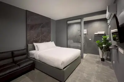 a small bedroom with a bed and a couch at HK Villa Resort in Bangkok