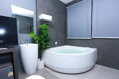 a bathroom with a large white tub and a sink at HK Villa Resort in Bangkok