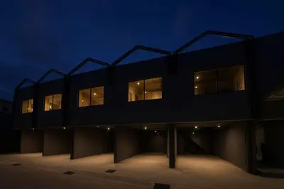 a black building with lit windows at night at HK Villa Resort in Bangkok