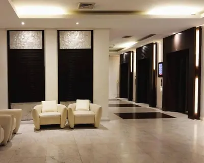 a lobby with two white chairs and windows at Riverview Condo Near Icon Siam Hi Speed Internet in Rat Burana
