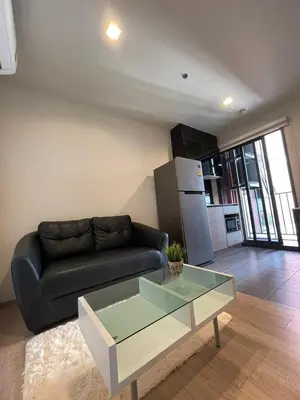 a living room with a black couch and a glass table at Private in Bangkapi in Bangkok