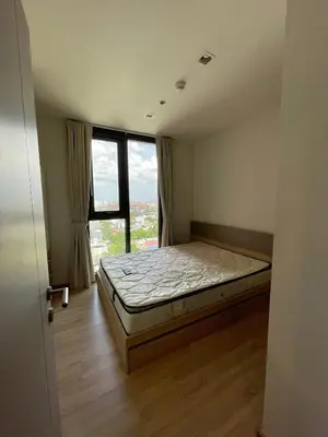 a bedroom with a bed and a large window at Private in Bangkapi in Bangkok