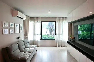 a living room with a couch and a large window at 2 Bedroom Life Ladprao in Bangkok