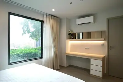 a bedroom with a bed and a window and a desk at 2 Bedroom Life Ladprao in Bangkok