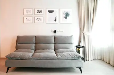 a couch sitting in a living room next to a window at 2 Bedroom Life Ladprao in Bangkok