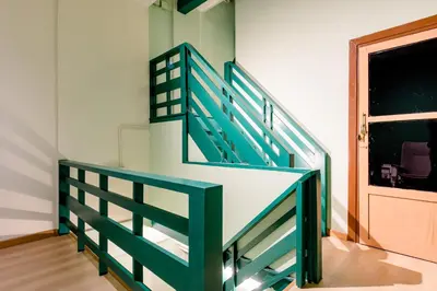 a green and white staircase in a room with a door at TermSuk Apt- Banthat Thong in Bangkok