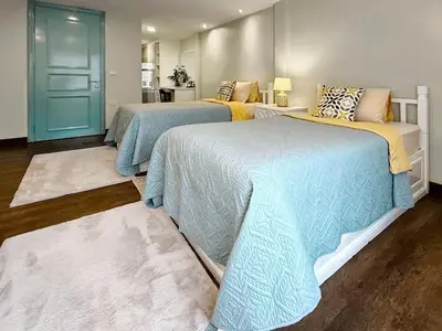 two beds with blue and yellow blankets in a room at Urban Charm & Unique at KIT-TI's Art Home Sukhumvit in Bangkok
