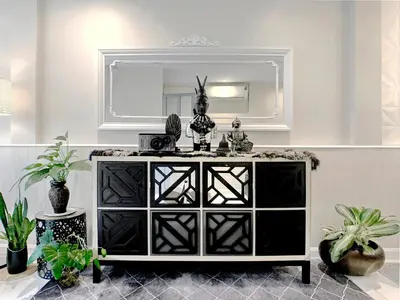 a black and white dresser in a room with plants at Urban Charm & Unique at KIT-TI's Art Home Sukhumvit in Bangkok