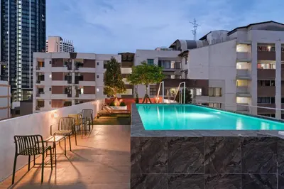 a rooftop patio with chairs and a swimming pool on a building at Hotel PaPa Ratchada-Huai Khwang in Bangkok