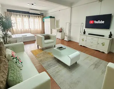 a living room with white furniture and a tv at Spacious, just an 850m walk to MRT Rama 9 station in Bangkok