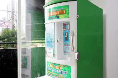 a green vending machine next to a green wall at UTD8 Hotel and Residence in Bangkok