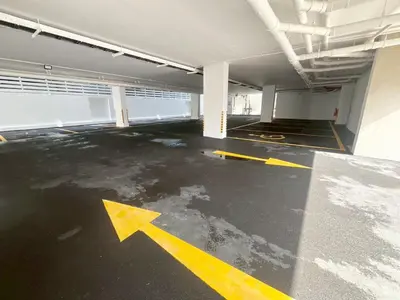 an empty parking garage with an arrow painted on the floor at UTD8 Hotel and Residence in Bangkok