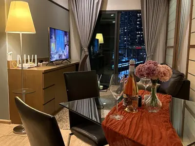a dining room with a table with flowers and wine glasses at Noble Remix Thong Lo Long Stay Cozy&Warm Direct access to BTS Pool Gym WiFi in Bangkok