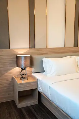 a bedroom with two beds and a lamp on a table at lee hotel lat phrao in Bangkok
