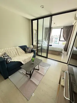 a living room with a couch and a table at Sukhumvit 50 apartment in Bangkok