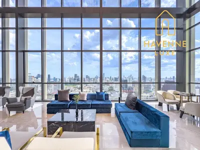 a large lobby with a blue couch and chairs at Luxury Downtown Bangkok 2BR 2BA Sky Pool Gym 5MIN Walk to Siam Paragon in Bangkok
