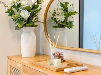 a table with two vases and a mirror at Luxury Downtown Bangkok 2BR 2BA Sky Pool Gym 5MIN Walk to Siam Paragon in Bangkok