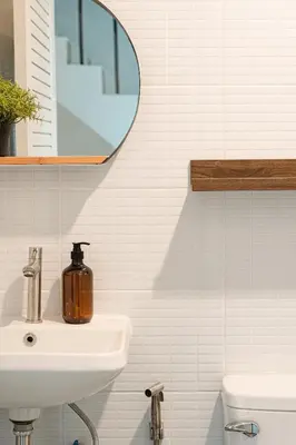 a white bathroom with a sink and a mirror at Roni House Thonglor in Bangkok