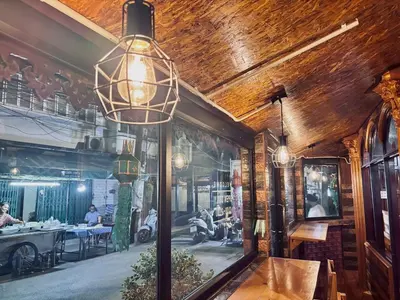 a dining room with a window with a picture of a restaurant at Sukhum Ban Songthai in Bangkok