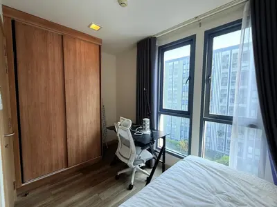a bedroom with a desk and a bed and a window at The Monti Condo in Bangkok