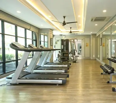a row of treadmills in a gym with windows at The Monti Condo in Bangkok