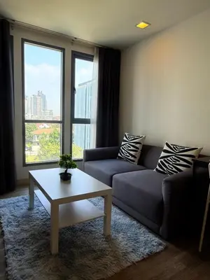 a living room with a couch and a coffee table at The Monti Condo in Bangkok