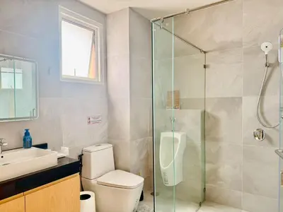 a bathroom with a shower and a toilet and a sink at The Prestige Living Bangkok at Sathorn-Chan in Bangkok