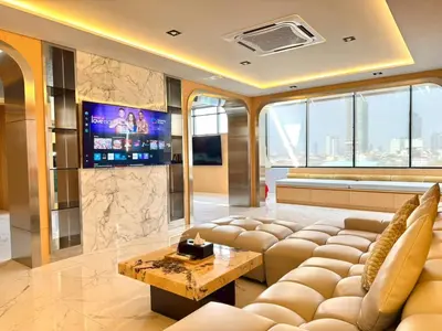 a living room with a couch and a tv at The Prestige Living Bangkok at Sathorn-Chan in Bangkok