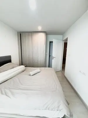a white bedroom with two beds in it at Bangkok apartment in Bangkok