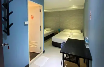 a small room with a bed and a desk in it at The Little Pig Sukhumvit in Bangkok