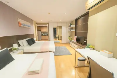 a large bedroom with a bed and a living room at Cozy Urban Retreat in Sukhumvit Steps to BTS Nana in Bangkok