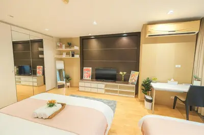 a bedroom with a bed and a desk and a television at Cozy Urban Retreat in Sukhumvit Steps to BTS Nana in Bangkok