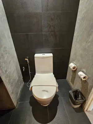 a bathroom with a white toilet in a stall at The Park Residence in Bangkok