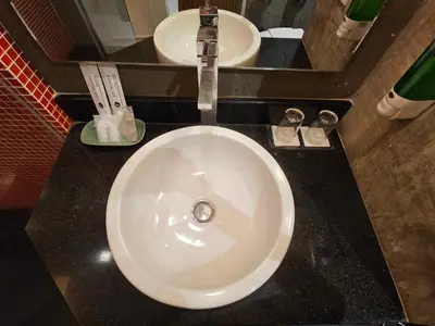 a white sink in a bathroom with two mirrors at The Park Residence in Bangkok