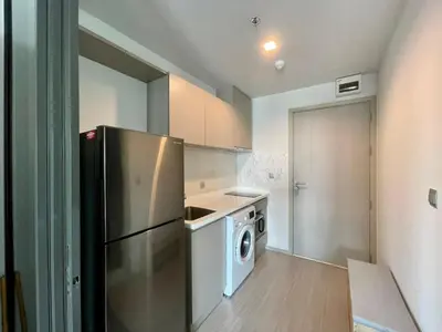 a kitchen with a refrigerator and a washing machine at 1 bedroom Life Ladprao in Bangkok