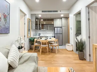 a living room with a table and a kitchen at Bangkok High-Floor Luxury Suite 2 Bedrooms 2 Bathrooms King & Queen Bed Sky Pool Heart of Siam District 曼谷高层奢华套房 两卧两卫 特大床 大床 无边泳池 坐落暹罗商圈核心 in Bangkok