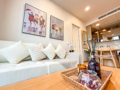 a living room with a white couch and a table at Bangkok High-Floor Luxury Suite 2 Bedrooms 2 Bathrooms King & Queen Bed Sky Pool Heart of Siam District 曼谷高层奢华套房 两卧两卫 特大床 大床 无边泳池 坐落暹罗商圈核心 in Bangkok