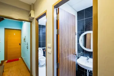 a bathroom with a toilet and a sink at Restiny Hostel in Bangkok